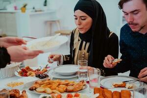 moslim familie hebben iftar avondeten drinken water naar breken feest. aan het eten traditioneel voedsel gedurende Ramadan feesten maand Bij huis. de Islamitisch halal aan het eten en drinken in modern huis foto