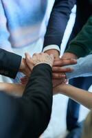 een top visie foto van groep van zakenlieden Holding handen samen naar symboliseren eenheid en sterkte