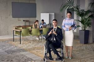 een zakenman in een rolstoel en zijn vrouw collega samen in een modern kantoor, vertegenwoordigen de macht van teamwerk, inclusie en steun, koesteren een dynamisch en inclusief werk omgeving. foto