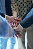 een top visie foto van groep van zakenlieden Holding handen samen naar symboliseren eenheid en sterkte