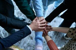 een top visie foto van groep van zakenlieden Holding handen samen naar symboliseren eenheid en sterkte