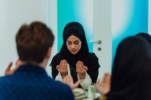 een moslim familie bidden samen, de moslim gebed na breken de snel in de Islamitisch heilig maand van Ramadan foto