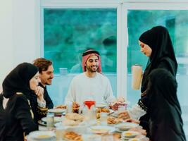 eid mubarak moslim familie hebben iftar avondeten drinken water naar breken feest. aan het eten traditioneel voedsel gedurende Ramadan feesten maand Bij huis. de Islamitisch halal aan het eten en drinken foto