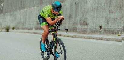 vol lengte portret van een actief triatleet in sportkleding en met een beschermend helm rijden een fiets. selectief focus foto