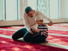 vader en zoon in moskee bidden en lezing hulst boek koran samen Islamitisch onderwijs concept foto