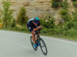 vol lengte portret van een actief triatleet in sportkleding en met een beschermend helm rijden een fiets. selectief focus foto