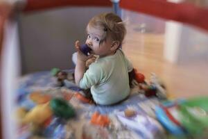 schattig weinig baby spelen in mobiel bed foto