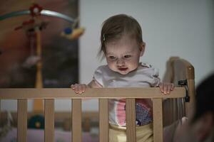 schattig weinig een jaar oud baby en maken eerste stappen in bed foto