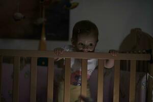 schattig weinig een jaar oud baby en maken eerste stappen in bed foto