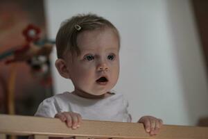 schattig weinig een jaar oud baby en maken eerste stappen in bed foto