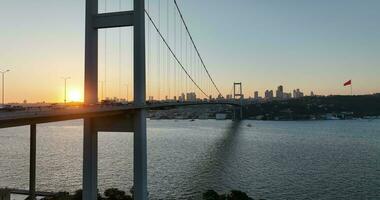 Istanbul Bosporus brug en stad horizon in achtergrond met Turks vlag Bij mooi zonsondergang, antenne glijbaan in een baan om de aarde en bijhouden schot foto