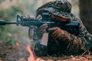 modern oorlogvoering soldaat omringd door vuur, strijd in dicht en gevaarlijk Woud gebieden foto