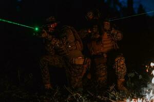 soldaten ploeg in actie Aan nacht missie gebruik makend van laser zicht straal lichten leger team concept foto