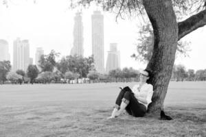 jonge vrouw die een boek in het park leest foto