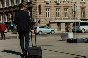 gaan naar luchthaven terminal. zelfverzekerd zakenman reiziger wandelen Aan stad straten en trekken zijn koffer drinken koffie en sprekend Aan smartphone foto