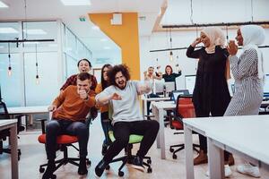 team gebouw en kantoor plezier. jong vrolijk mensen uit het bedrijfsleven in slim gewoontjes slijtage hebben pret terwijl racing Aan kantoor stoelen en lachend. foto