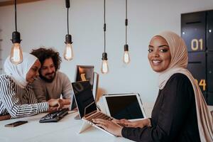 groep van multi-etnisch collega's werken Aan bureaublad computers, laptop en sharing hun ideeën in een modern kantoor ruimte.jong beïnvloeders werk Aan online afzet projecten. foto