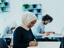 foto van een Afrikaanse Amerikaans moslim vrouw wezen geleerd over bedrijf ontwikkeling in een modern klas