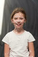 portret van een weinig school- meisje met waterpokken, antiseptisch room toegepast naar gezicht en lichaam .schoolbord achtergrond. foto
