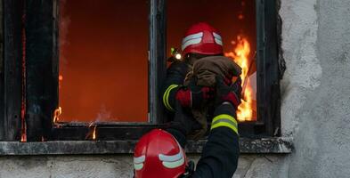 brandweerman held draag- baby meisje uit van brandend gebouw Oppervlakte van brand incident. redden mensen van gevaarlijk plaats foto