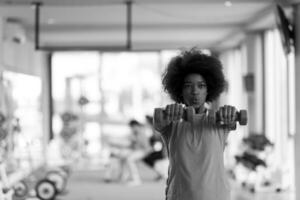 vrouw werken uit in een crossfit Sportschool met halters foto