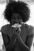 vrouw met afro kapsel aan het eten smakelijk pizza plak foto