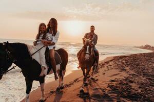 de familie besteedt tijd met hun kinderen terwijl rijden paarden samen Aan een zanderig strand. selectief focus foto