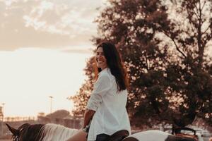 vrouw in zomer kleren geniet rijden een paard Aan een mooi zanderig strand Bij zonsondergang. selectief focus foto