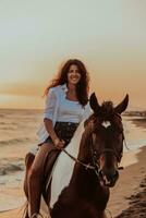 vrouw in zomer kleren geniet rijden een paard Aan een mooi zanderig strand Bij zonsondergang. selectief focus foto