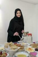 jong moslim vrouw portie voedsel voor iftar gedurende Ramadan foto
