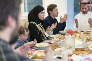 moslim familie maken iftar dua naar breken vastend gedurende Ramadan. foto