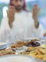 moslim familie maken iftar dua naar breken vastend gedurende Ramadan. foto