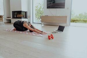 jong mooi vrouw sporten, uitrekken en beoefenen yoga met trainer via video telefoontje conferentie in helder zonnig huis. gezond levensstijl, welzijn en opmerkzaamheid concept. foto