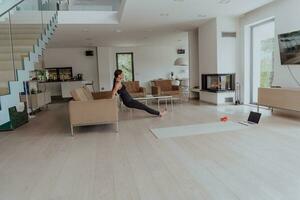 jong mooi vrouw sporten, uitrekken en beoefenen yoga met trainer via video telefoontje conferentie in helder zonnig zolder appartement. gezond levensstijl, welzijn en opmerkzaamheid concept. foto