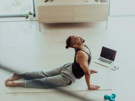 opleiding Bij huis. sportief Mens aan het doen opleiding terwijl aan het kijken online zelfstudie Aan laptop, oefenen in leven kamer, vrij ruimte foto