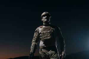 leger soldaat in gevecht uniformen met een aanval geweer, bord vervoerder en gevecht helm gaan Aan een gevaarlijk missie Aan een regenachtig nacht. foto