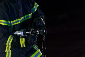 brandweerlieden gebruik een water slang naar elimineren een brand gevaar. team van brandweer in de gevaarlijk redden missie. foto