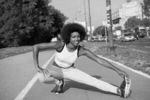 portret van sportieve jonge Afro-Amerikaanse vrouw die zich buiten uitstrekt foto