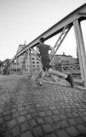 man joggen over de brug op zonnige ochtend foto