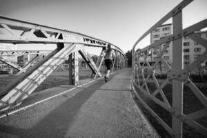 vrouw joggen over de brug op zonnige ochtend foto