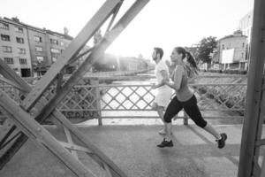 jong stel joggen over de brug in de stad foto