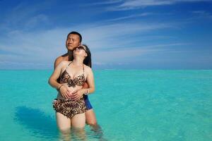 gelukkig jong paar genieten van zomer Aan strand foto