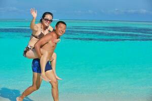 gelukkig jong paar genieten van zomer Aan strand foto