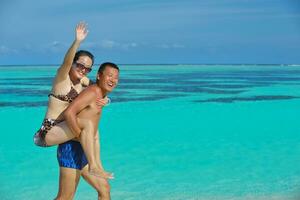 gelukkig jong paar genieten van zomer Aan strand foto