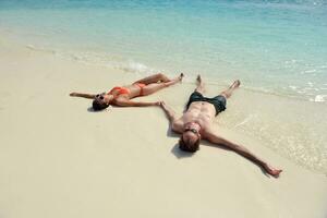 gelukkig jong koppel veel plezier op het strand foto