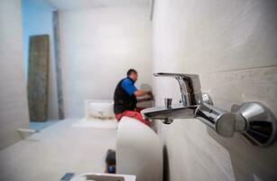 professioneel loodgieter werken in een badkamer foto
