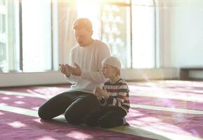 vader en zoon in moskee bidden en lezing hulst boek koran samen foto