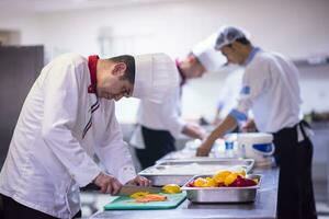 chef snijdend vers en heerlijk groenten foto