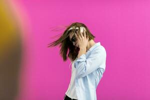 brunette dame in zwart bril dansen en luisteren muziek- isoleren Aan roze achtergrond foto