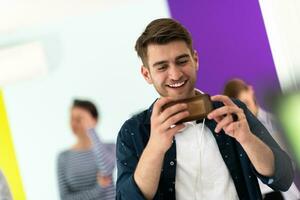 verschillend tieners gebruik makend van mobiel apparaten terwijl poseren voor een studio foto in voorkant van een kleurrijk achtergrond